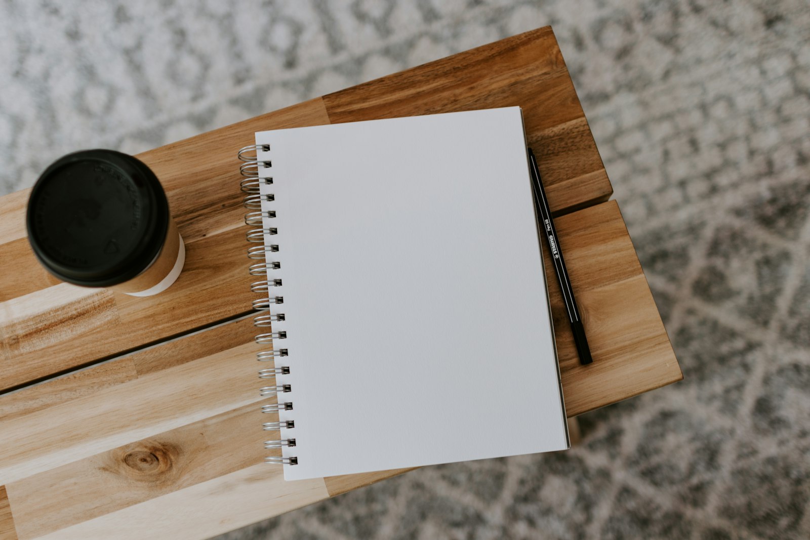A blank notebook and pencil on a wooden desk, ready for outlining a new story